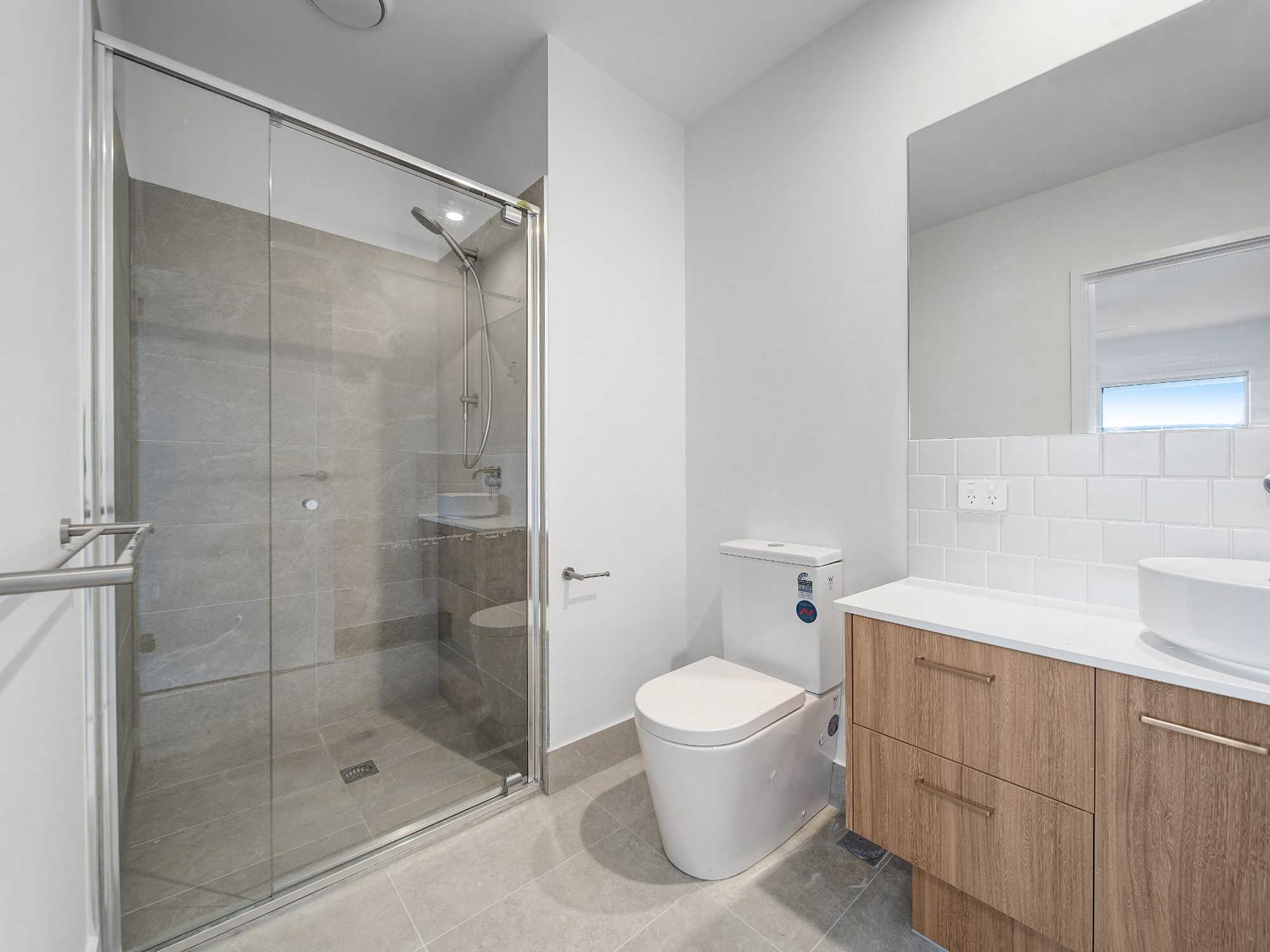 Completed bathroom with semi-frameless shower and timber vanity