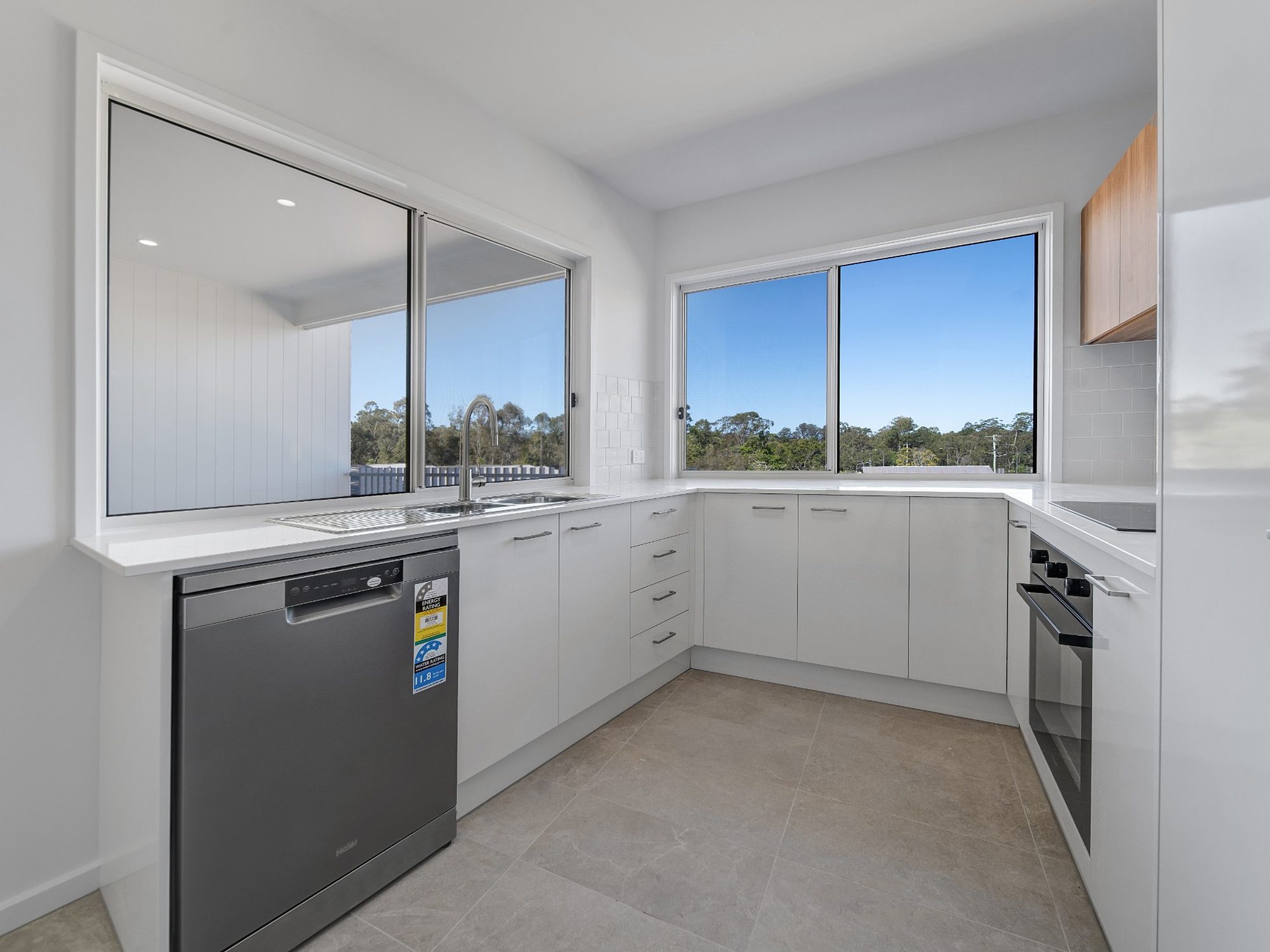 Completed kitchen with stone benchtops and a bushland outlook